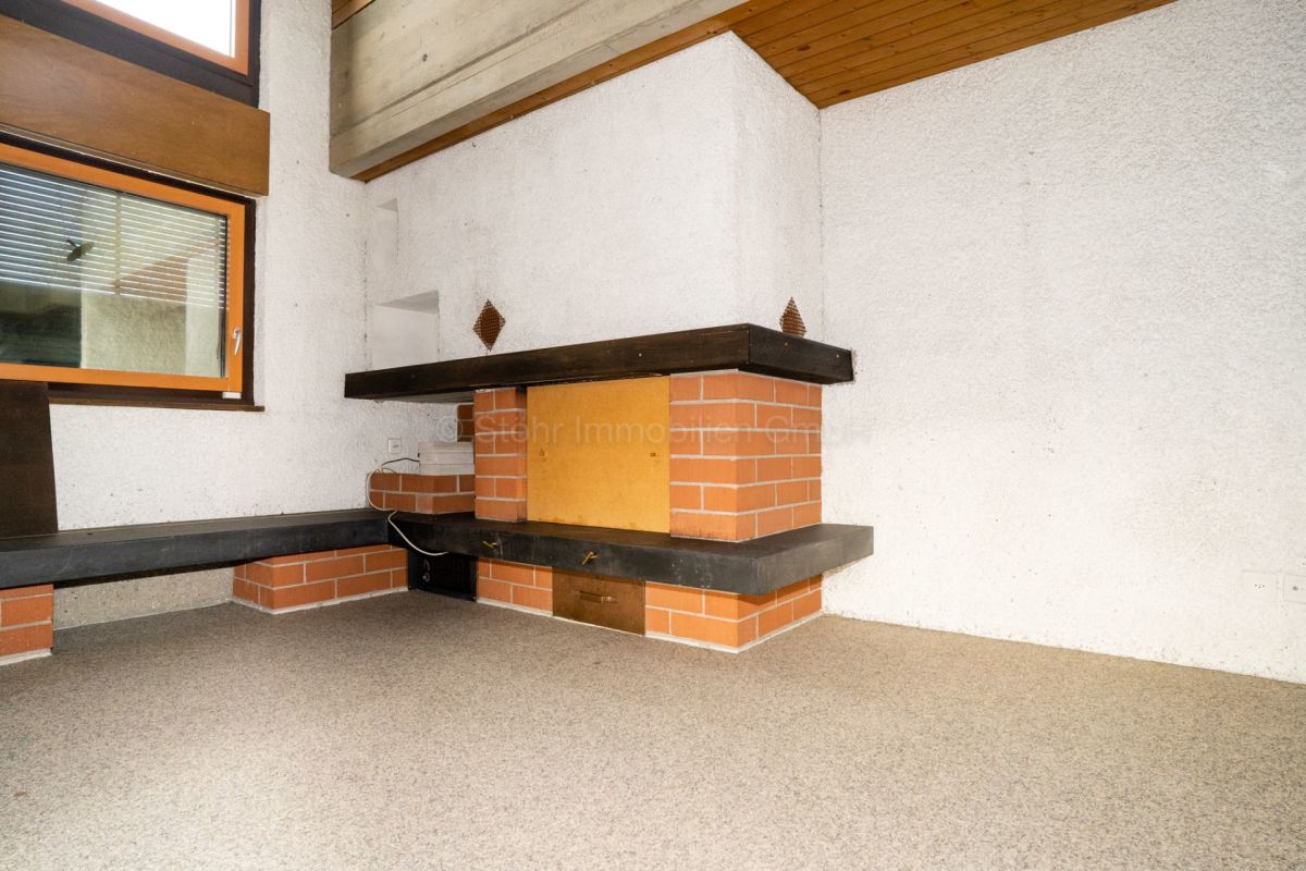 Wohnraum mit Kamin und hoher Decke