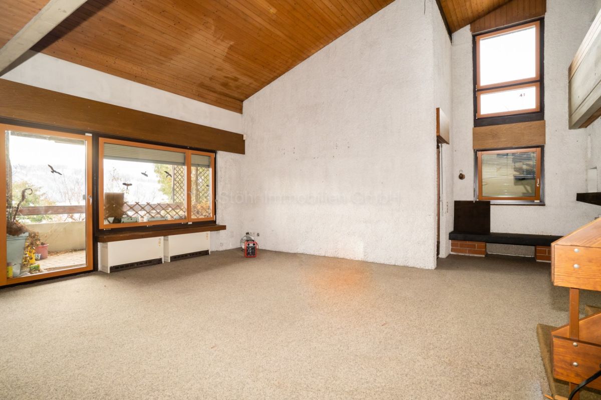 Wohnraum mit hoher Decke und Holzverkleidung
