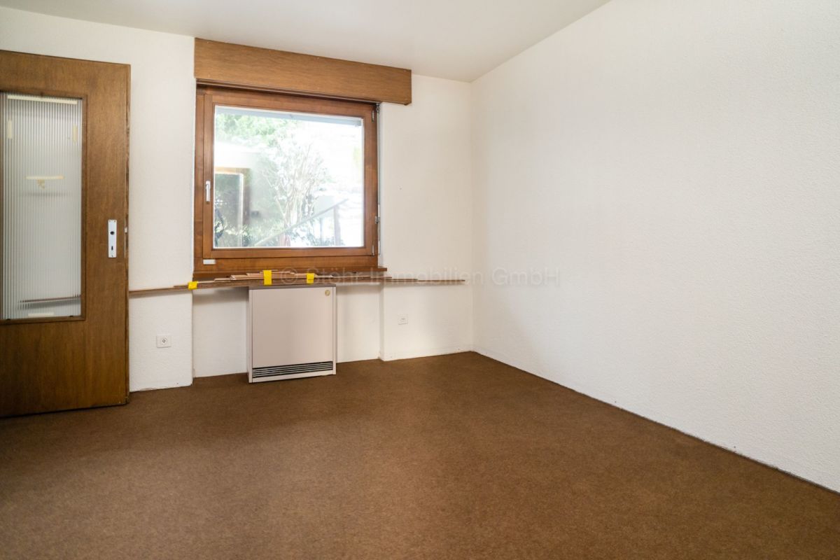 Leerer Raum mit Holzfenster und Teppichboden