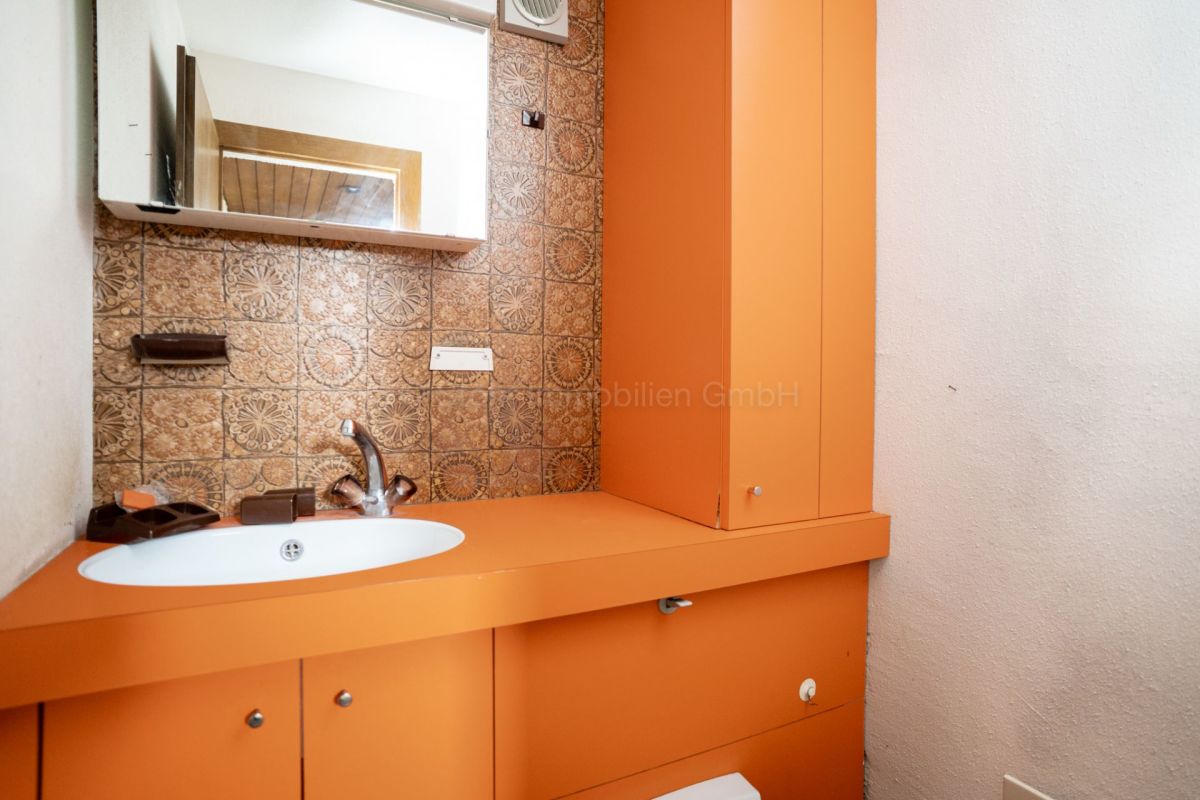 Orangefarbenes Gäste-WC mit Waschbecken