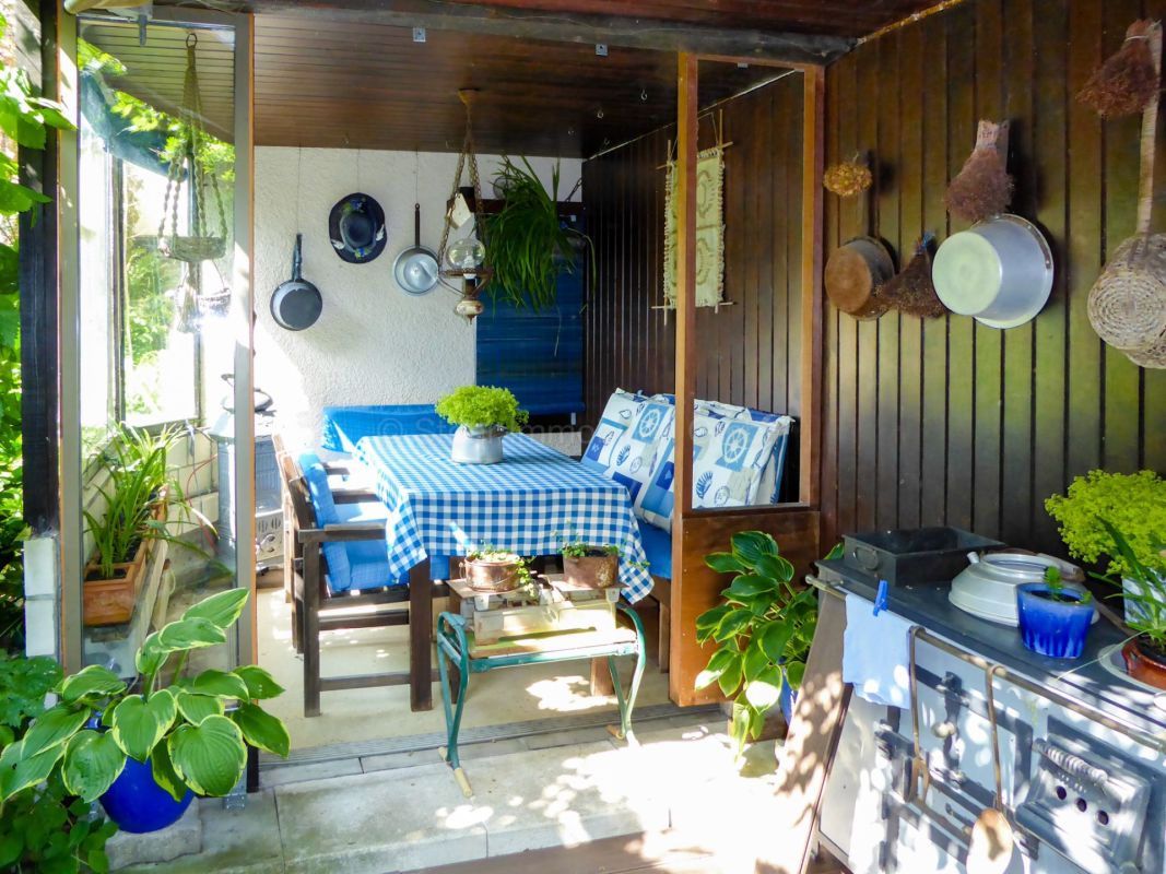 Überdachte Terrasse mit gemütlicher Ess- und Kochzone