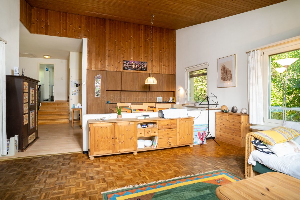 Wohnzimmer mit Holzvertäfelung und viel Tageslicht
