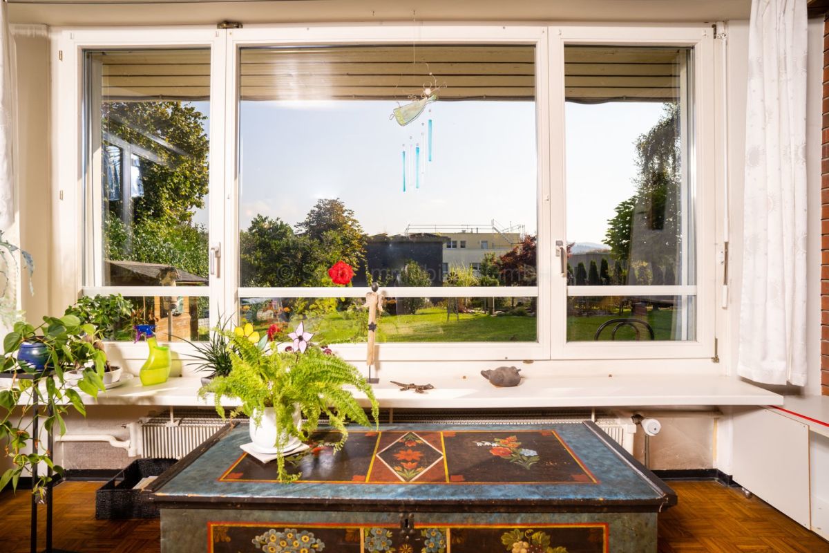 Wohnzimmer mit großem Fenster und Gartenausblick