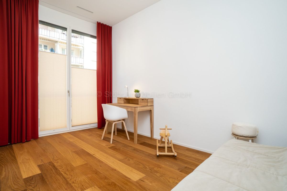 Helles Zimmer mit Balkonzugang und Holzfußboden