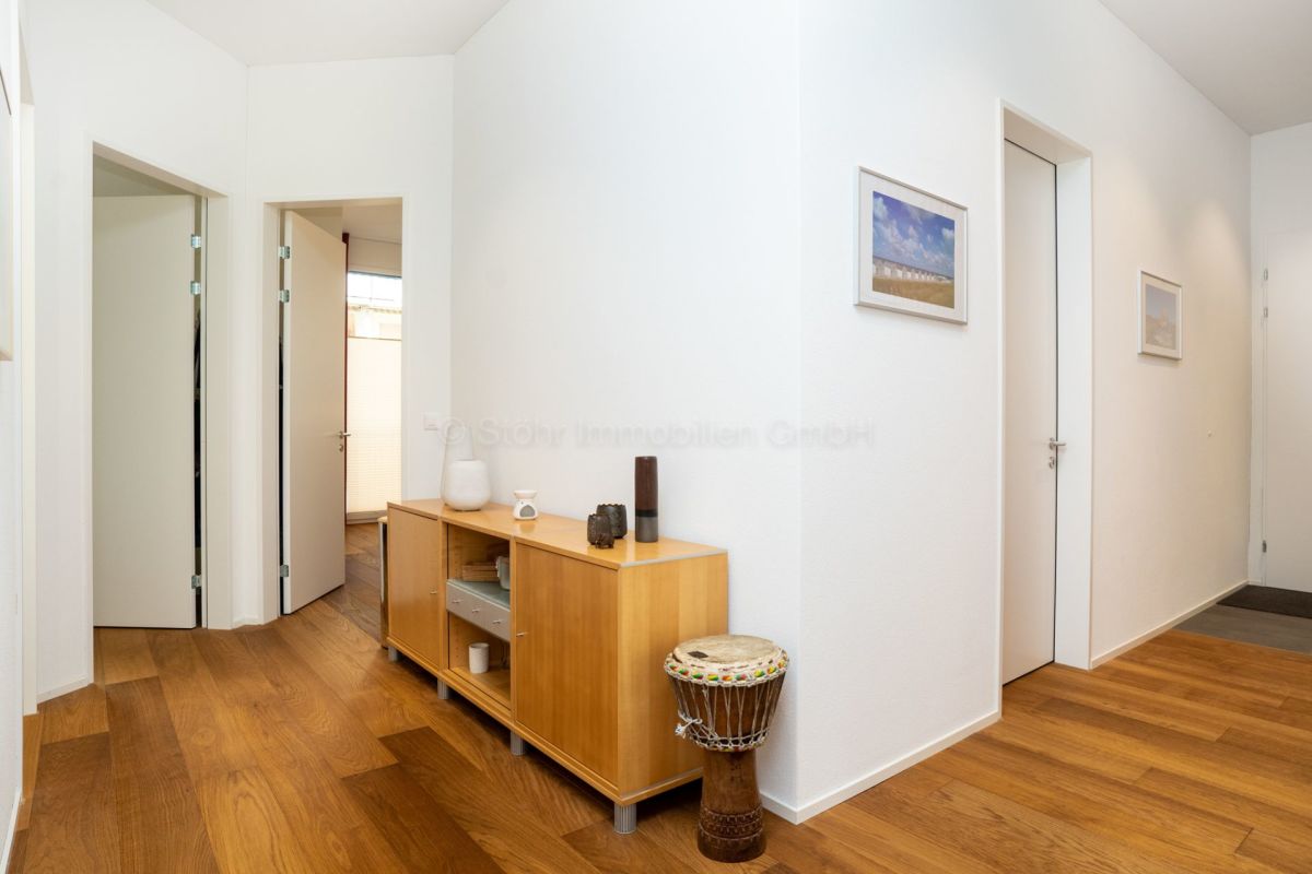 Heller Flur mit Holzfußboden und weißen Türen