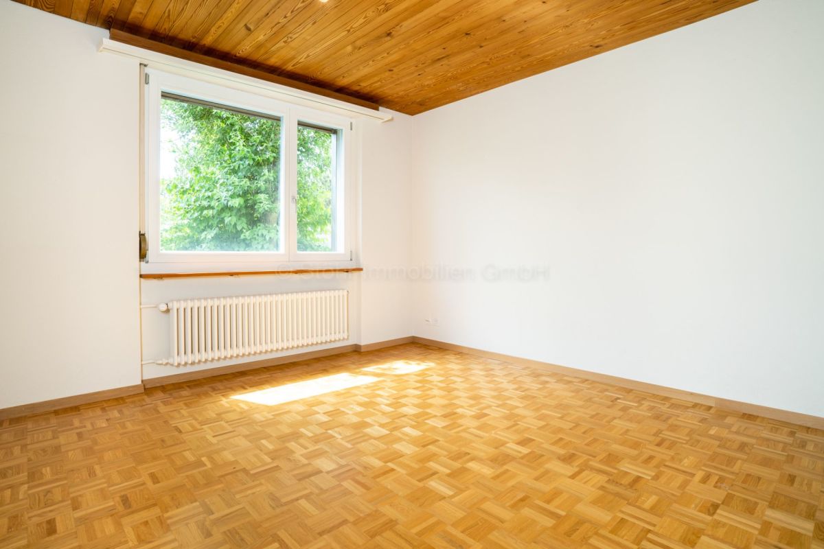 Heller leerer Raum mit Holzdecke und Parkettboden