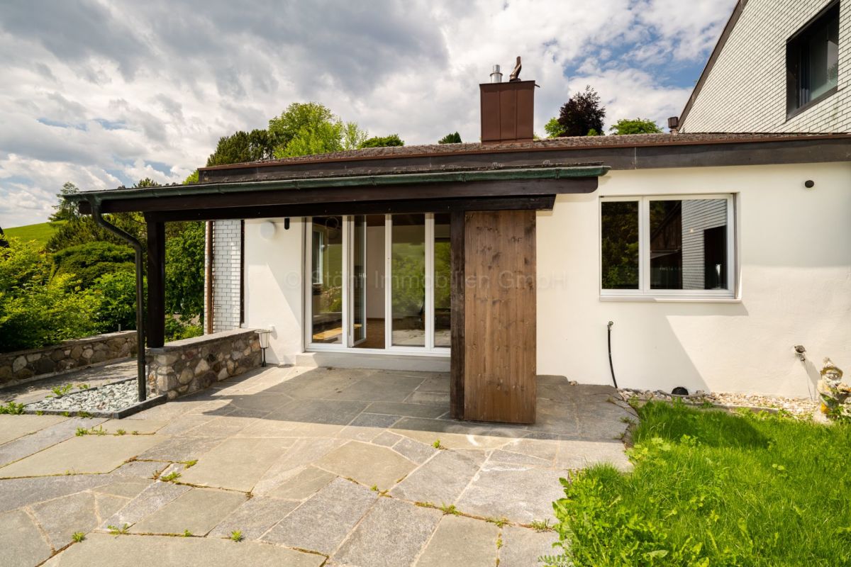 Terrasse und Hausrückseite mit überdachtem Zugang