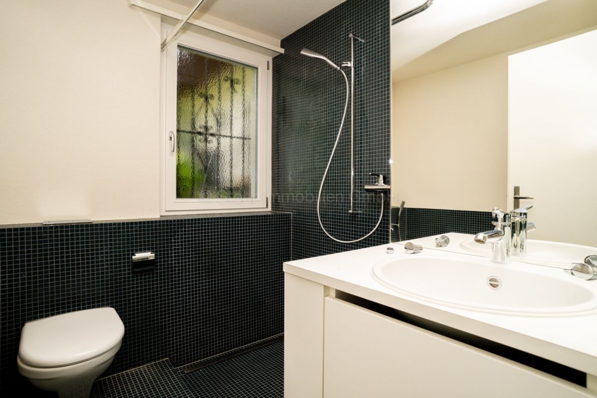 Modernes Badezimmer mit dunkler Mosaikverkleidung