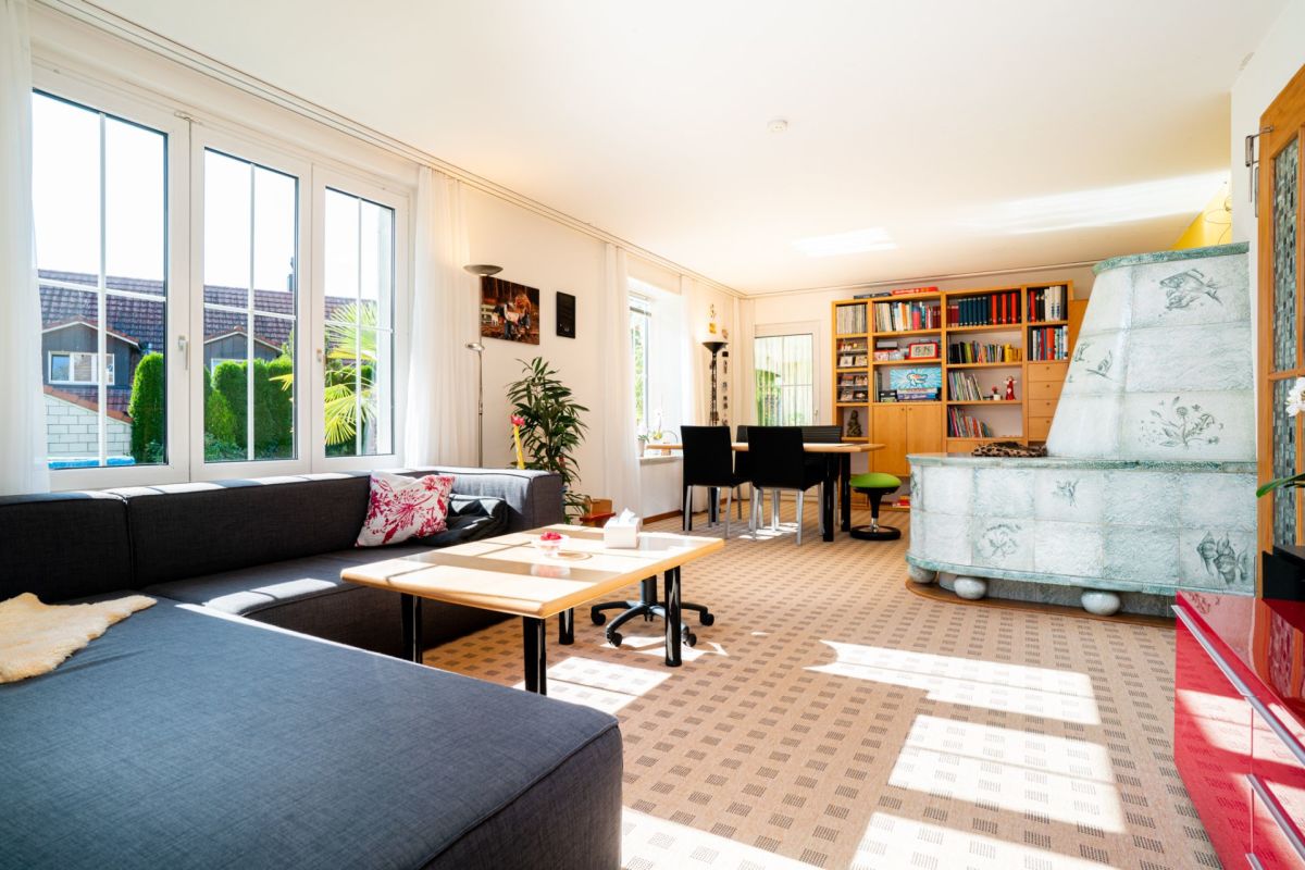 Helles Wohn-Esszimmer mit Bücherregal und Kamin