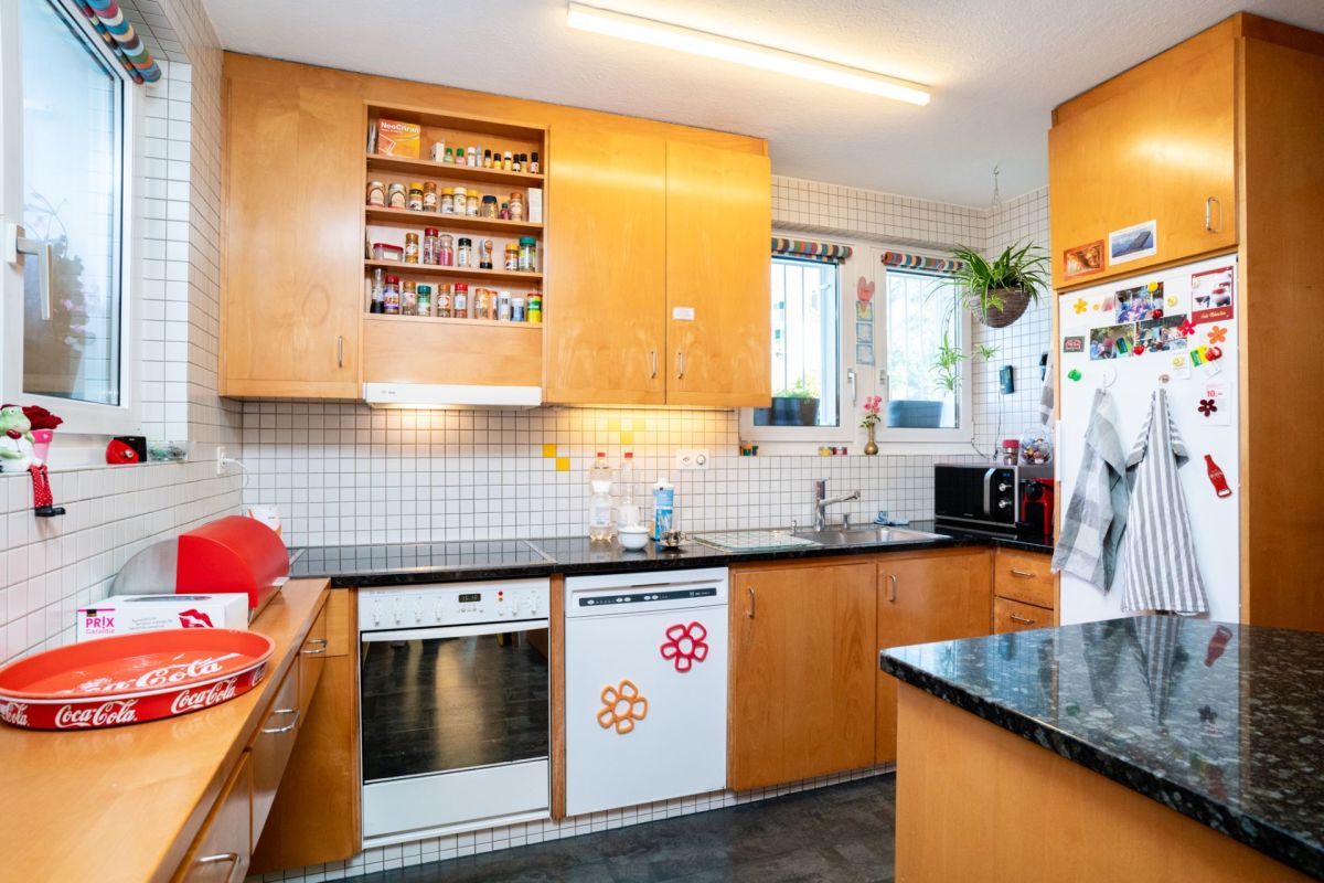 Küche mit Holzfronten und schwarzer Arbeitsplatte