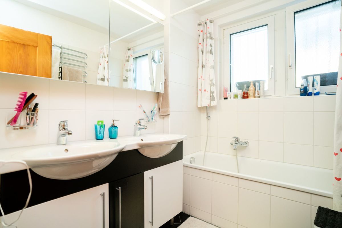 Helles Badezimmer mit Doppelwaschbecken und Badewanne
