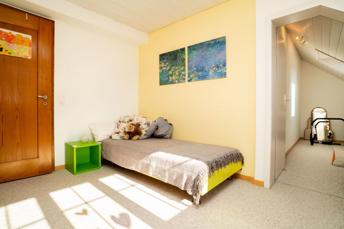 Kinderzimmer mit Bett und Dachschräge