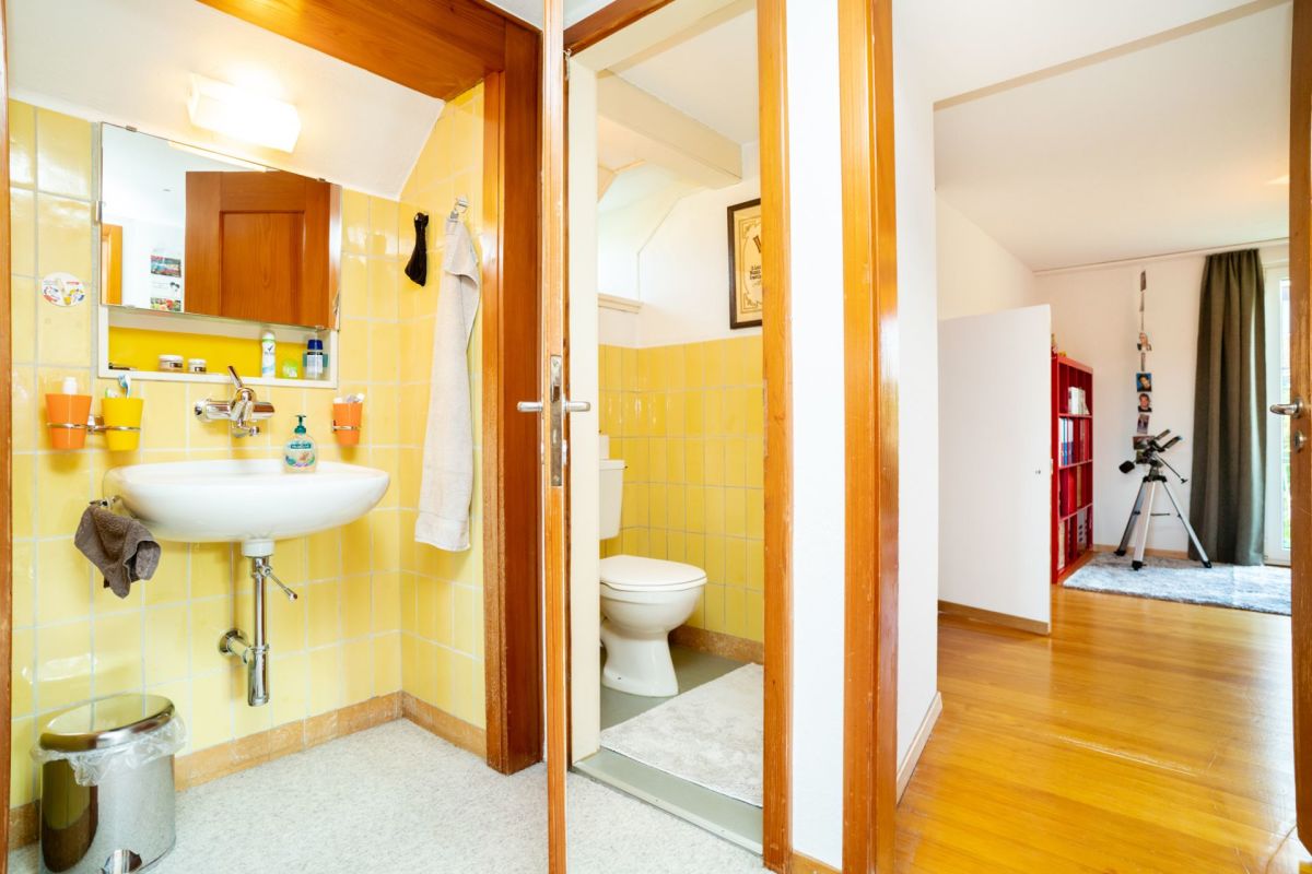 Badezimmerflur mit Blick in ein WC und ein angrenzendes Schlafzimmer