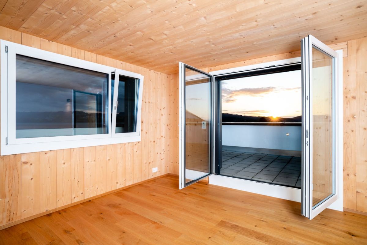 Holzverkleideter Raum mit Balkonblick bei Sonnenuntergang