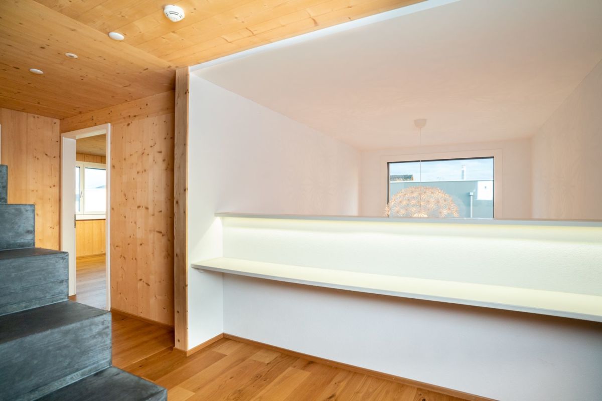 Treppenaufgang mit Holz und weißem Durchgang
