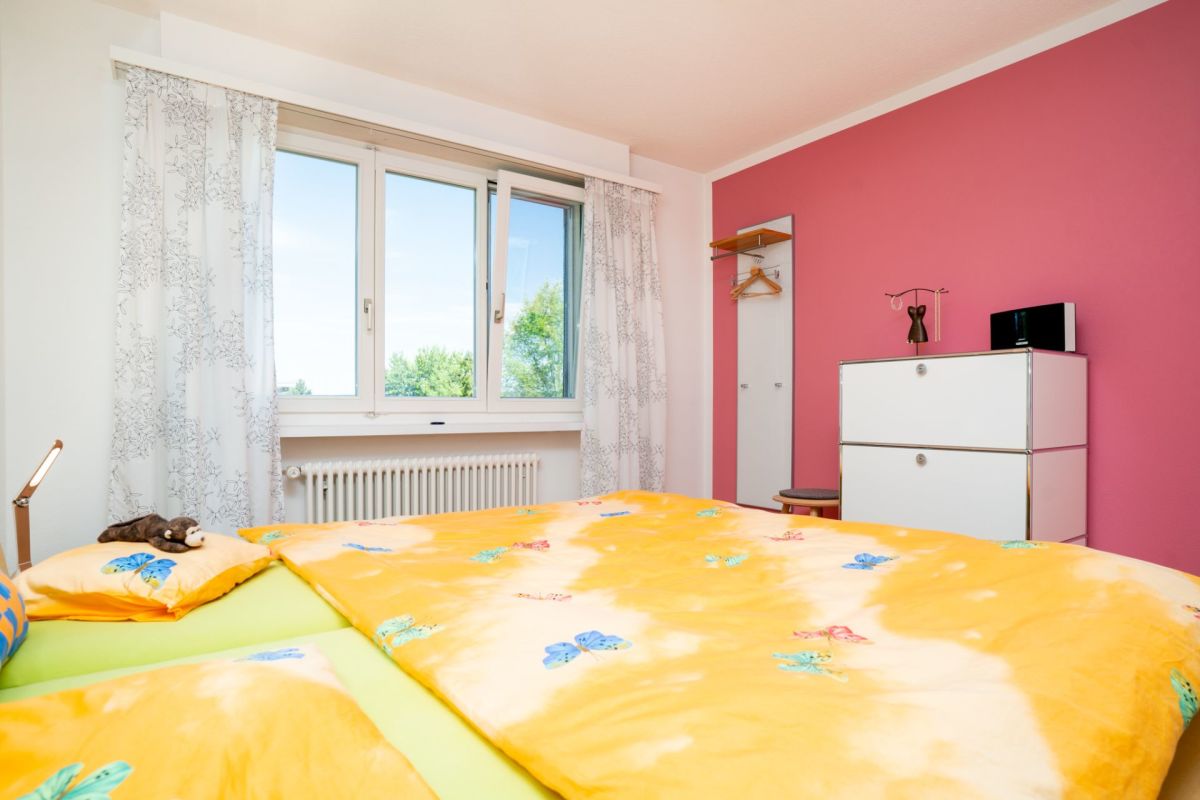 Buntes Schlafzimmer mit Doppelbett und Fenster