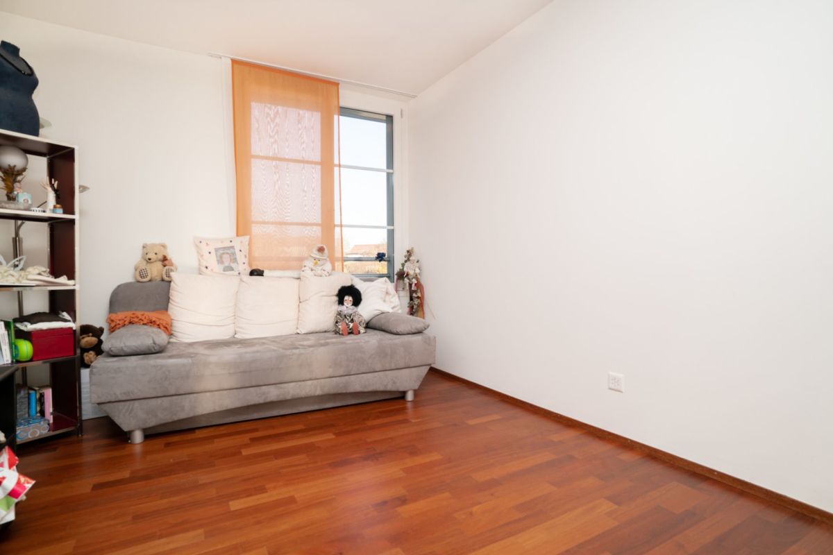Kleines, helles Zimmer mit Sofa und Fenster
