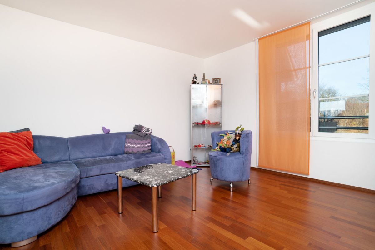 Helles Wohnzimmer mit blauem Sofa und Holzboden