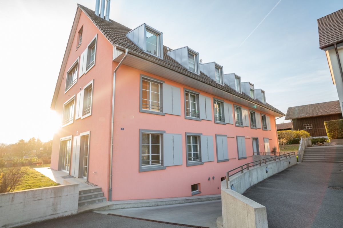 Außenansicht eines rosafarbenen Mehrfamilienhauses