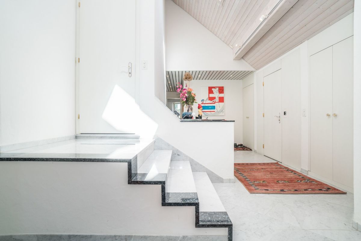 Heller Flur mit Treppe und weißen Türen