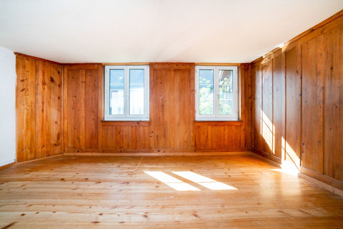 Holzvertäfelter leerer Raum mit zwei Fenstern