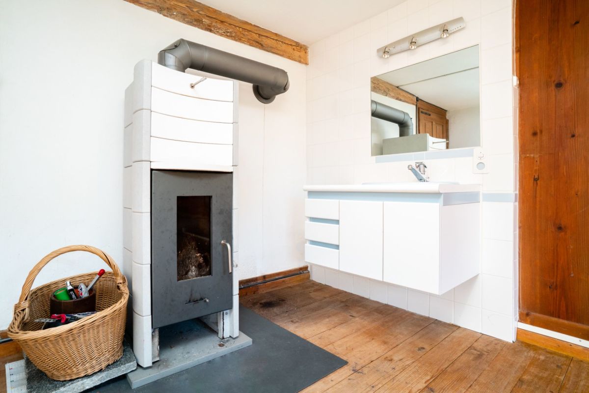 Kleines Badezimmer mit Holzofen und Waschtisch