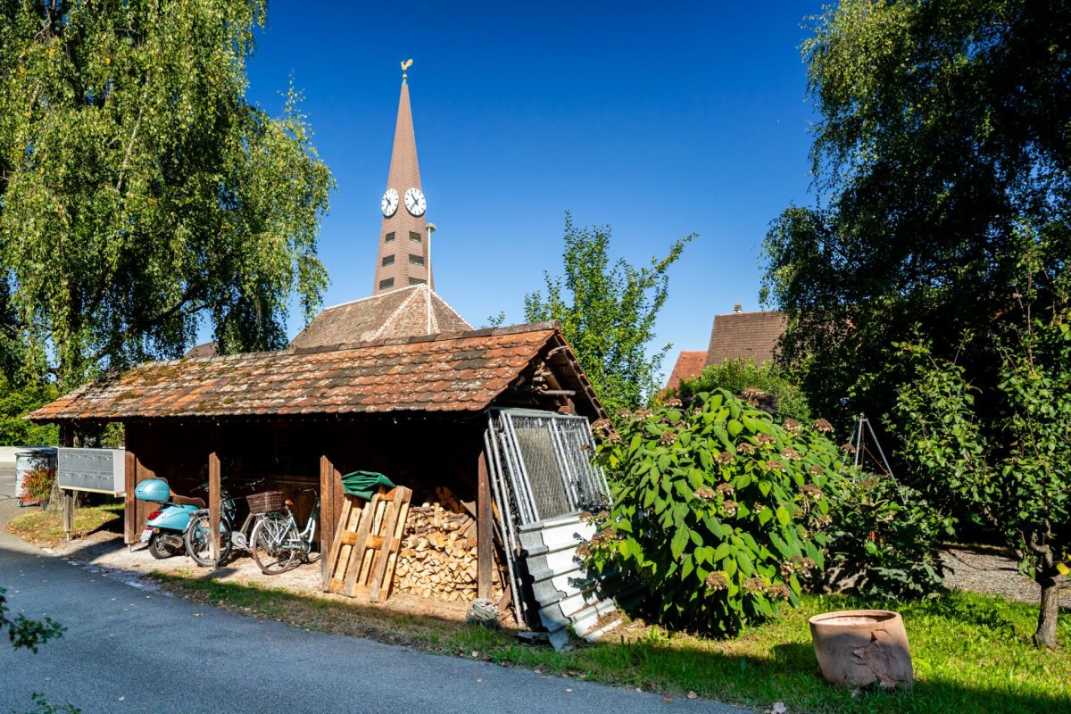 Gartenhaus mit Kirchturm im Hintergrund