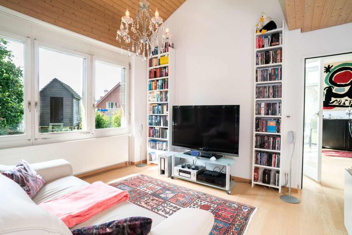 Helles Wohnzimmer mit TV und Bücherregalen