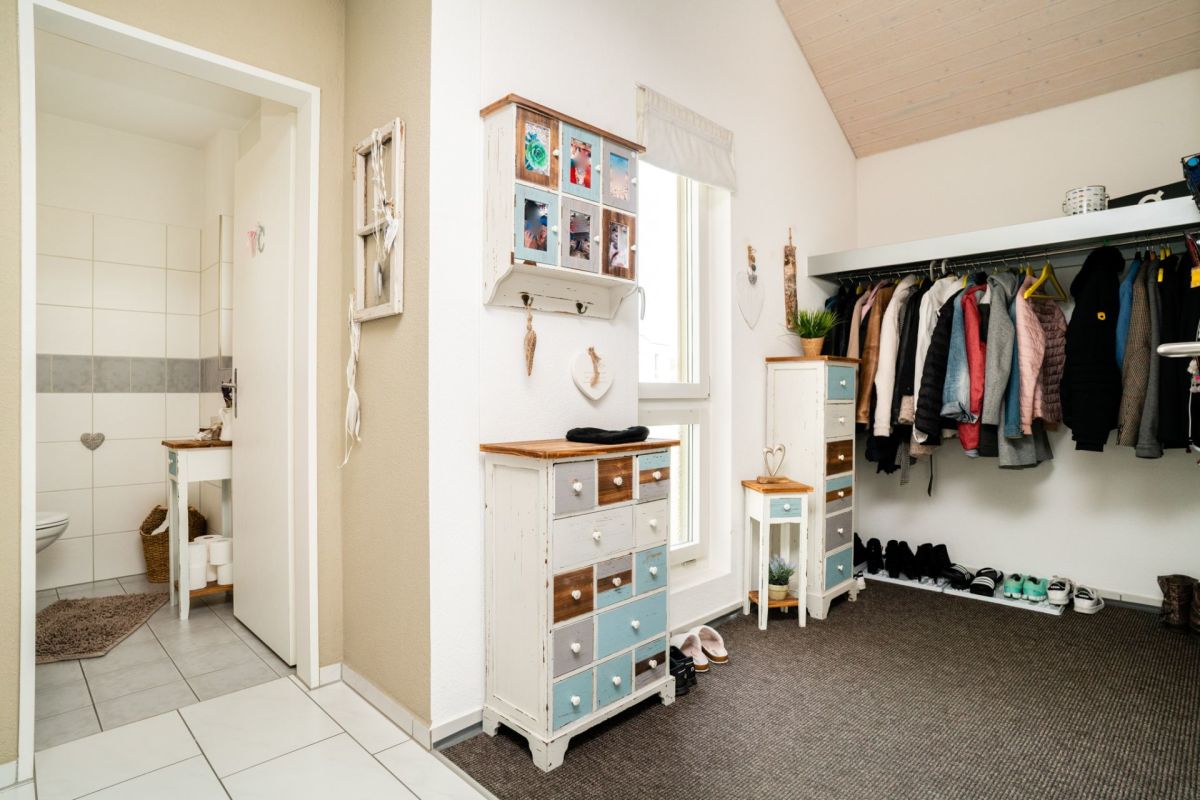 Heller Eingangsbereich mit Garderobe und Blick ins Bad