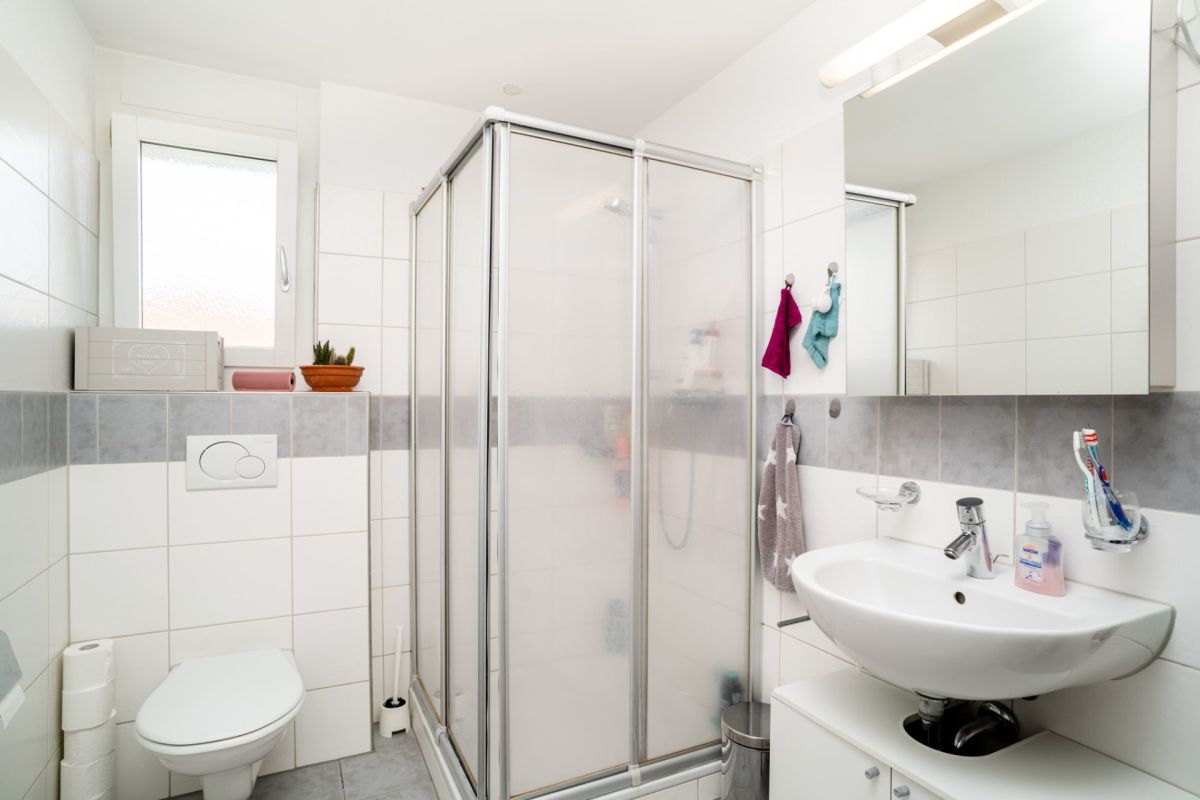 Kompaktes, modern wirkendes Badezimmer mit Dusche, WC und Waschplatz