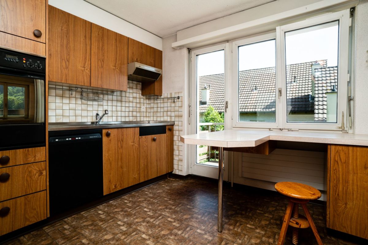Küche mit Holzfronten und großem Fenster