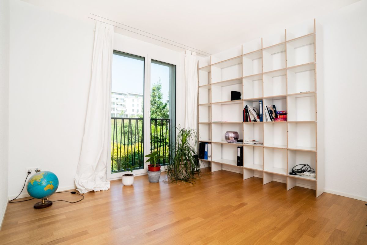 Helles Zimmer mit großem Fenster und Regalsystem