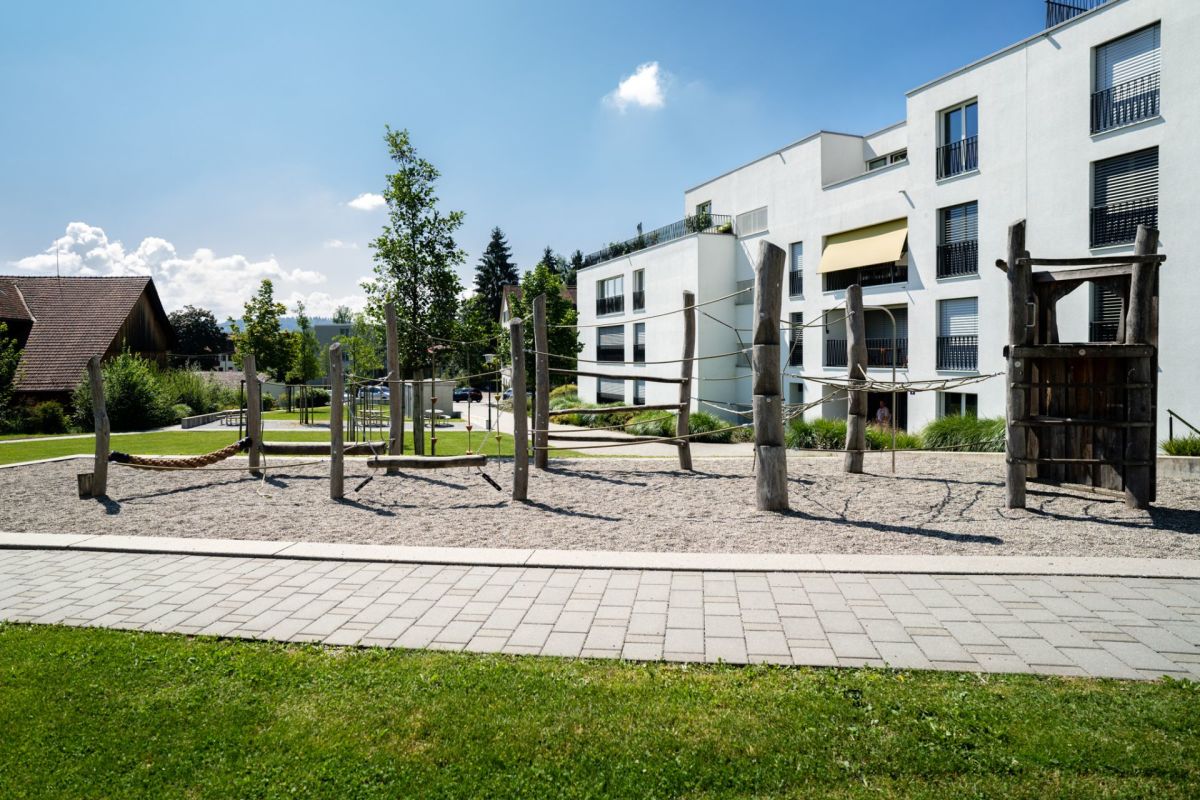 Außenansicht mit Spielplatz vor moderner Wohnanlage