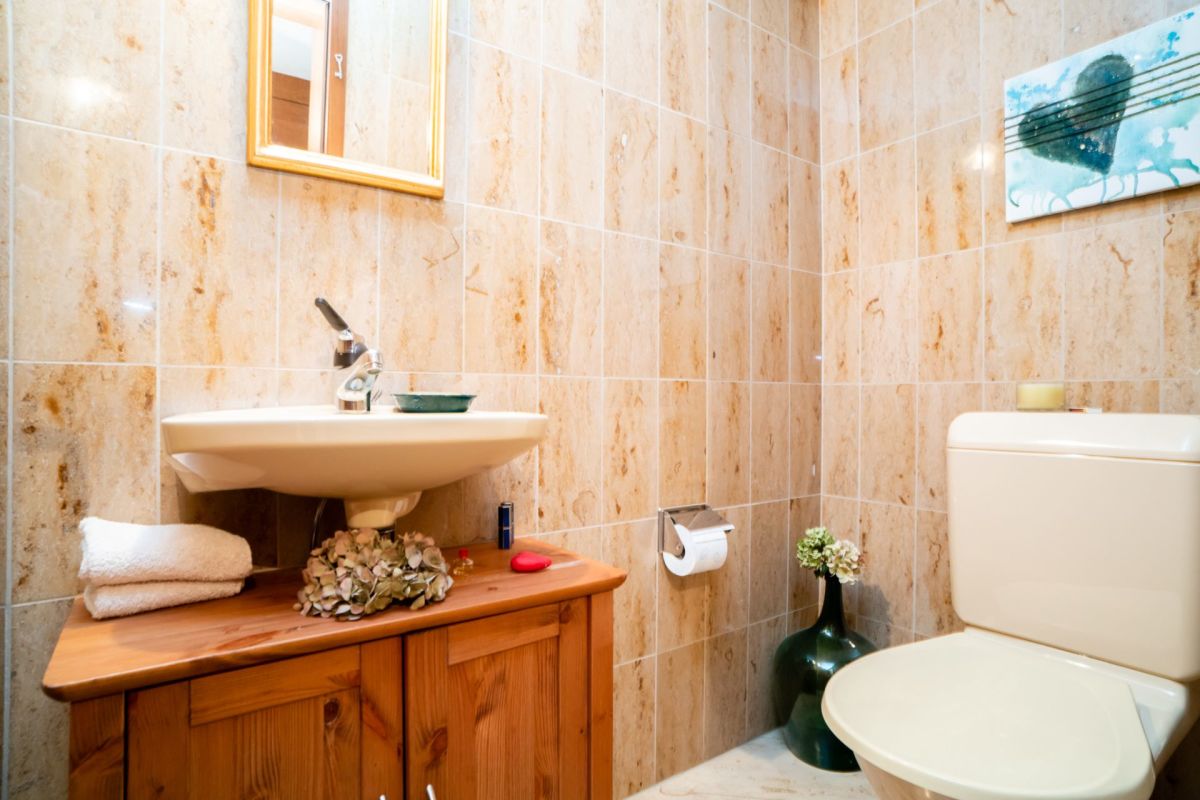 Gäste-WC mit Natursteinfliesen und Holzwaschtisch