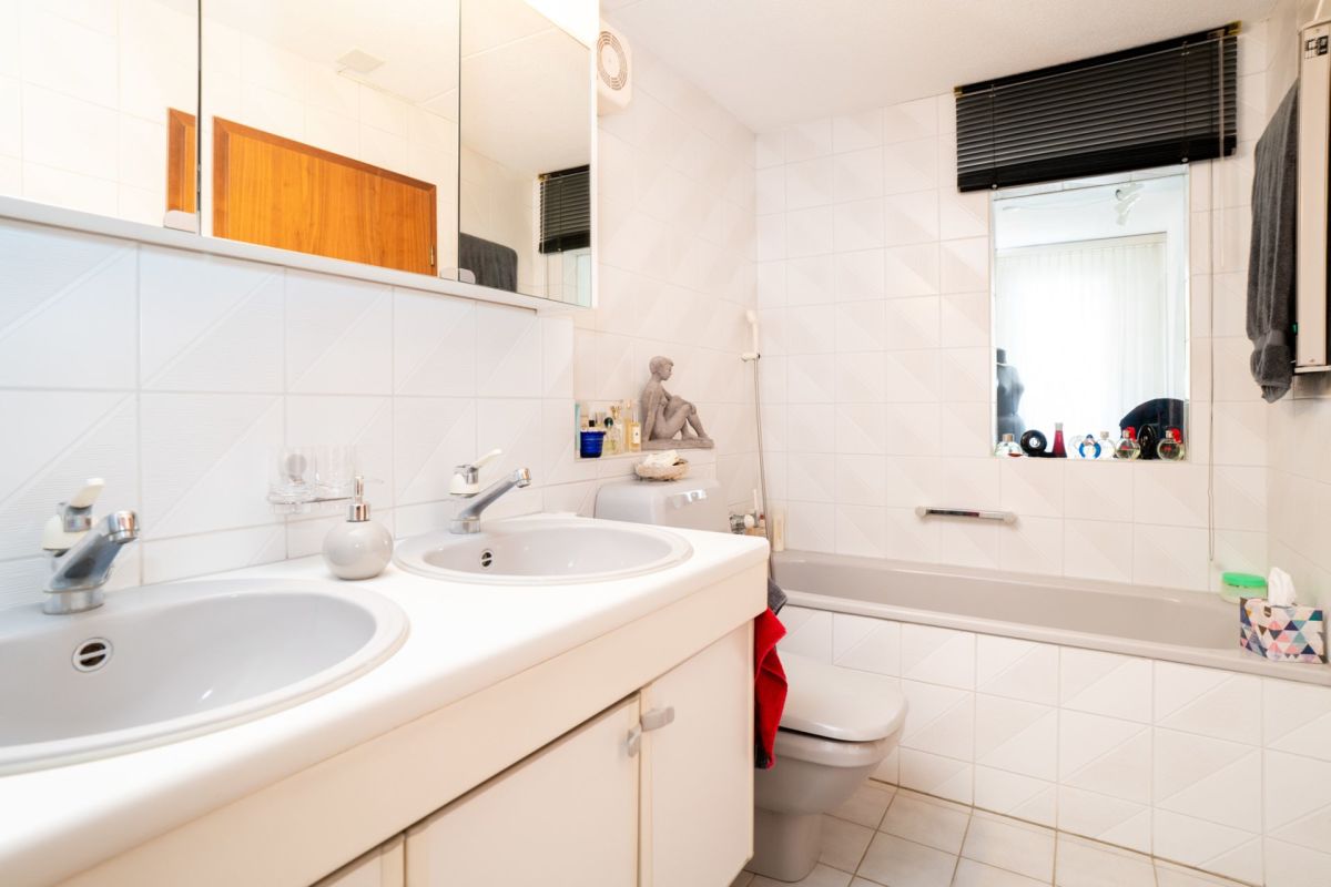 Helles Badezimmer mit Doppelwaschtisch und Wanne