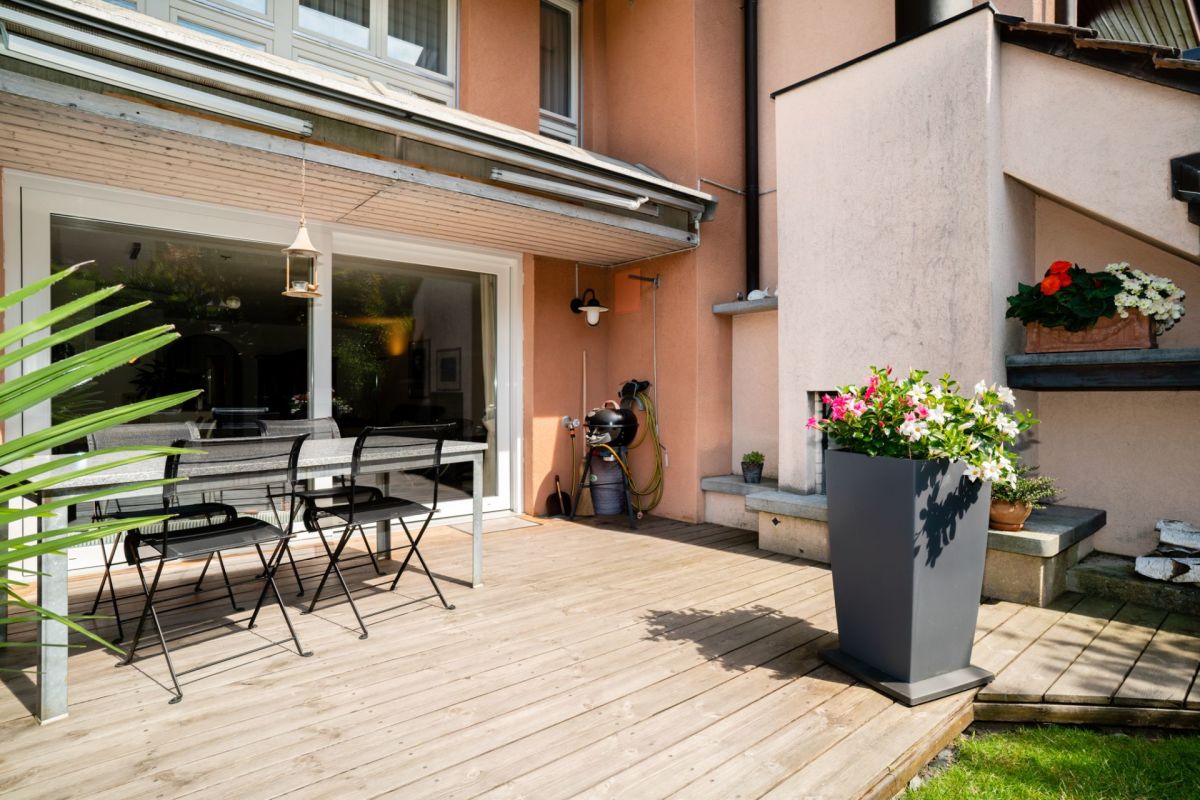 Terrasse mit Gartenmöbeln und Pflanzgefäßen