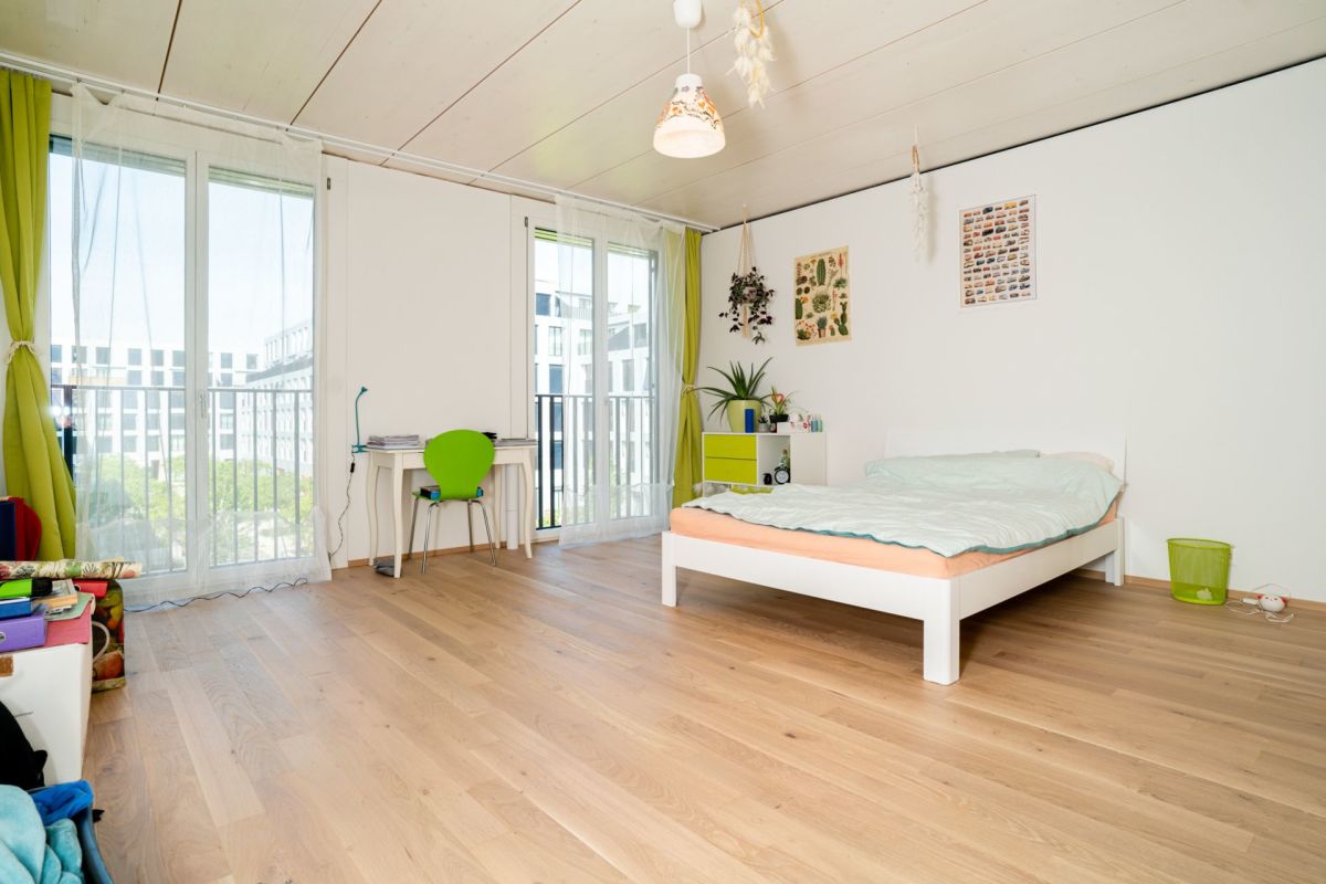Helles Schlafzimmer mit Balkon und Holzboden
