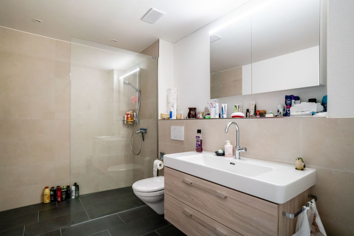 Modernes Badezimmer mit bodengleicher Dusche und Waschtisch