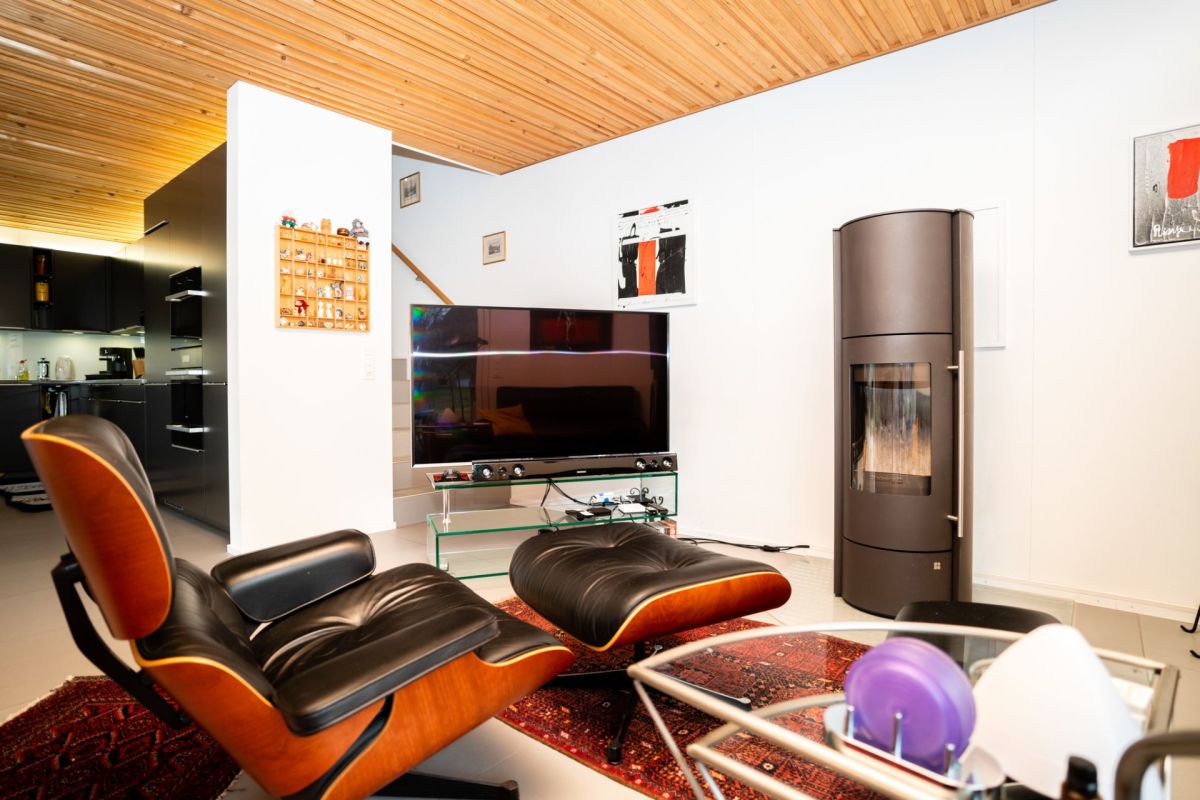 Modernes Wohnzimmer mit Holzdecke und Designofen