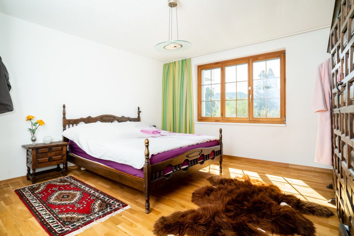 Schlafzimmer mit Holzmöbeln und Fensterblick