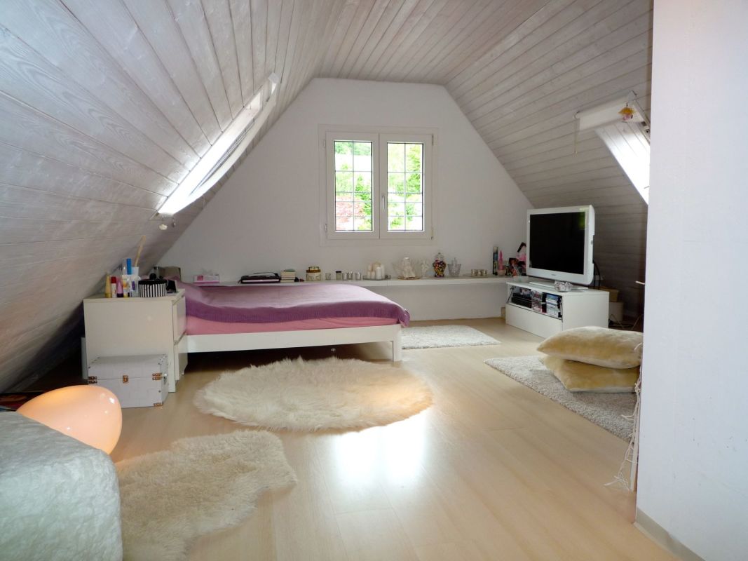 Dachgeschoss-Schlafzimmer mit Sitz- und TV-Bereich