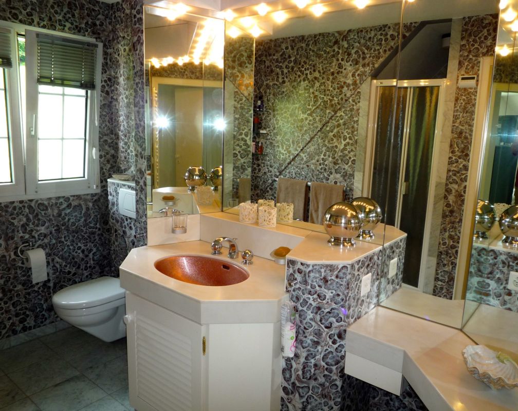 Badezimmer mit Mosaikwänden und Doppelspiegel