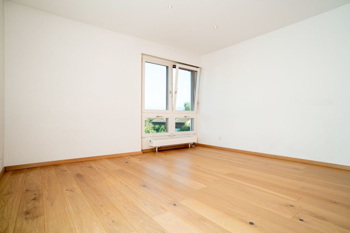 Leeres helles Zimmer mit Holzparkett und Fenster