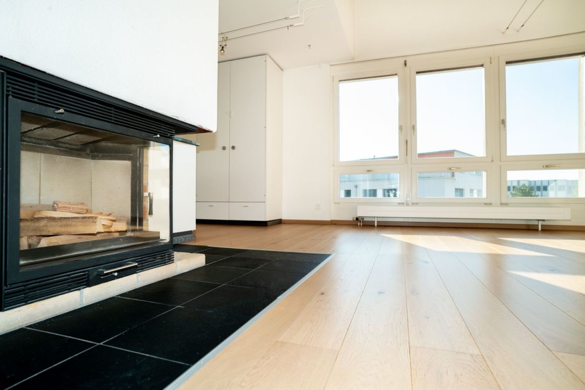 Heller Wohnraum mit Kamin und großen Fenstern