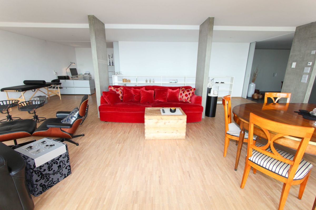 Offener Wohn- und Essbereich mit rotem Sofa