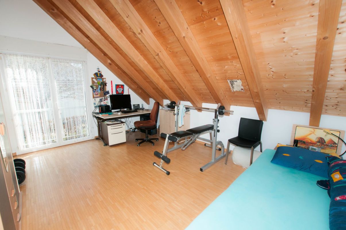 Dachzimmer mit Arbeits- und Fitnessbereich