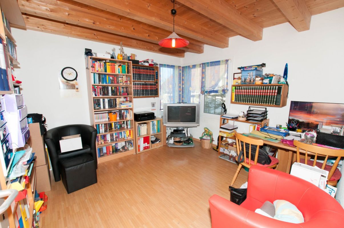 Wohnzimmer mit Arbeitsbereich und Bücherregalen