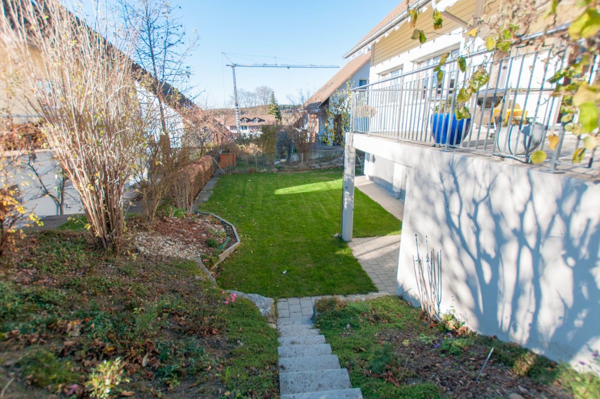Garten mit Terrasse und Hausansicht