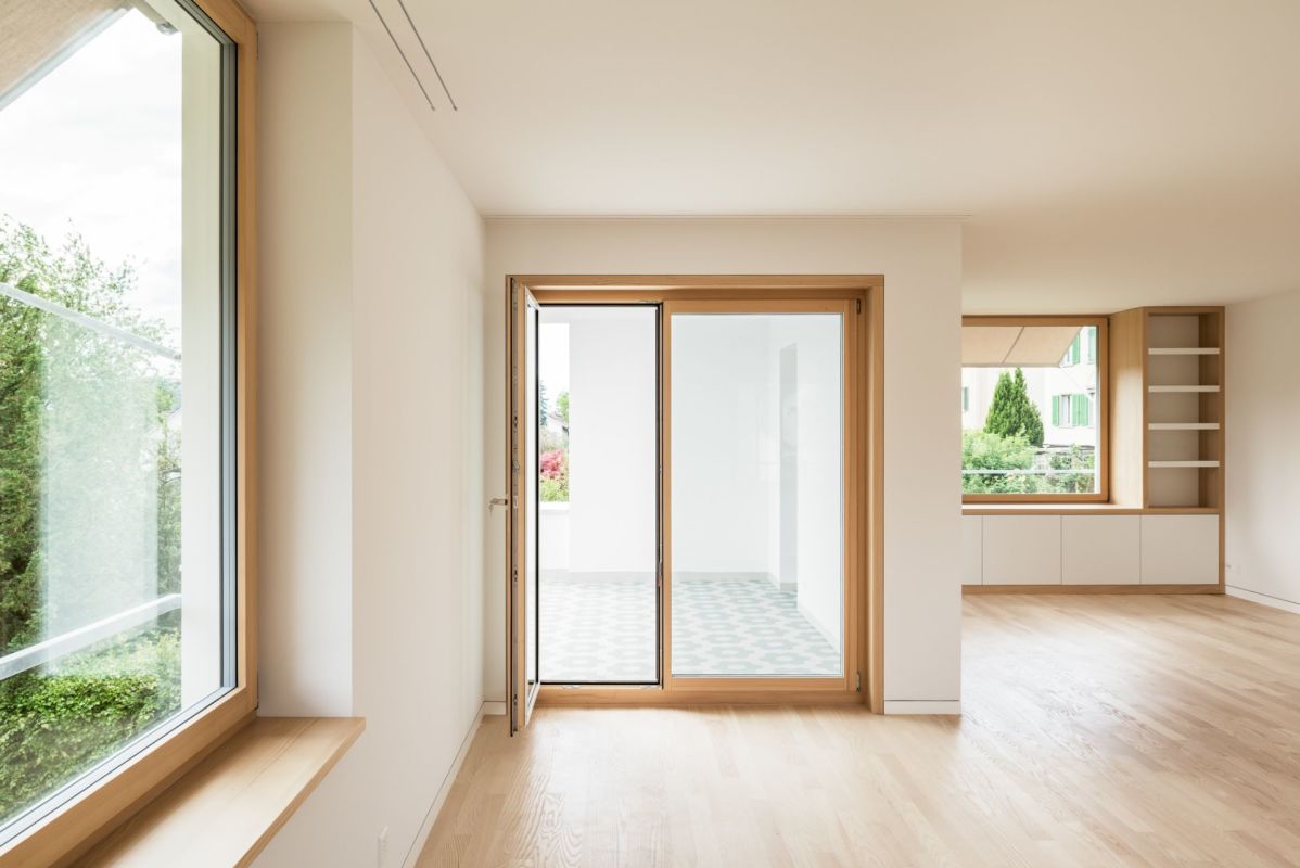 Heller Wohnraum mit Holzfenstern und Terrassentür