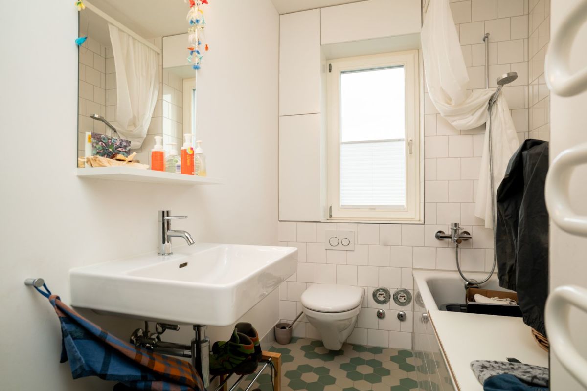 Helles Badezimmer mit Fenster und Badewanne